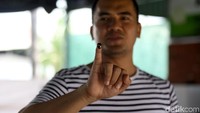 Saipul Jamil menunjukkan jari kelingkingnya yang telah dicelupkan tinta usai mencoblos.