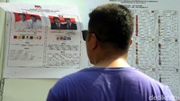 Seorang warga tengah memantau contoh surat suara.