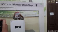 Setelah validasi, pemilih dipanggil untuk dapat kertas dan nyoblos di bilik suara. Pemilih ini ingin menunjukkan kertas suara yang dia dapat belum tercoblos, alias masih bersih tanpa ada bekas tusukan paku. (Rosmha Widiyani/detikHealth) 
