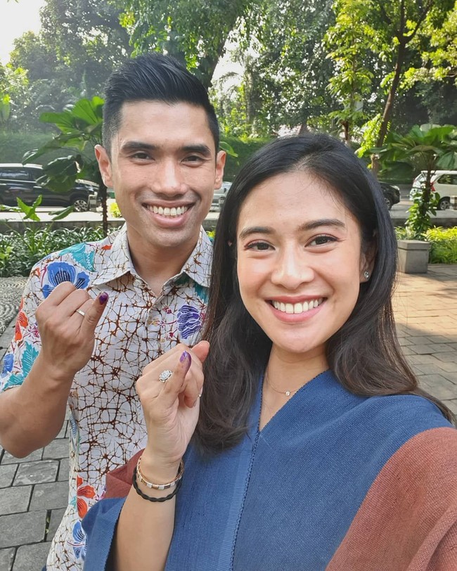 Dian Sastrowardoyo tampil dengan busana biru aksen coklat. Sementara sang suami mengenakan batik. Mereka berpose menunjukkan kelingkin dengan tinta sebagai bukti telah menyoblos.  Foto: Instagram