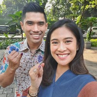 Dian Sastrowardoyo tampil dengan busana biru aksen coklat. Sementara sang suami mengenakan batik. Mereka berpose menunjukkan kelingkin dengan tinta sebagai bukti telah menyoblos.  Foto: Instagram