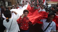 Sejumlah pendukung Jokowi-Amin membentangkan bendera raksasa saat pawai dari Rumah Aspirasi Jokowi, Jakarta Pusat, Rabu (17/4).
