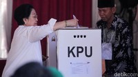 Megawati memasukkan kertas suara yang telah dicoblos ke kotak suara.