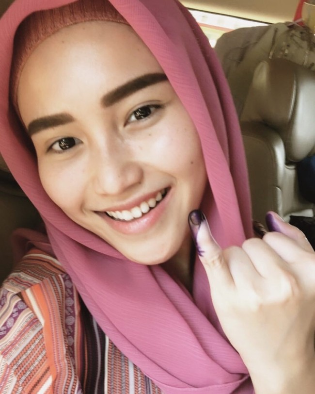 Ayu Ting Ting yang baru pulang Umrah tampil berhijab saat nyoblos. Pedangdut 26 tahun itu menggunakan hijab warna pink.  Foto: Instagram