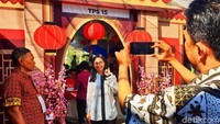 Beberapa warga foto-foto dengan latar belakang TPS yang bernuansa Tionghoa tersebut.