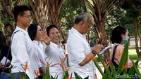 Ia pun pamer senyum saat mengantre untuk mencoblos.