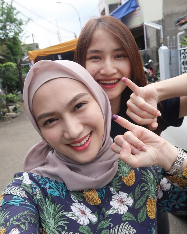 Melody Laksani atau populer dengan sebutan Melody Eks JKT 48 memilih atasan bermotif tropikal saat mengunjungi TPS. Ia memadukan atasan kasual itu dengan hijab segi empat voile berwarna mocca. Foto: Instagram