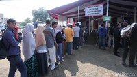 Tampak warga telah mengantre di pintu masuk, sementara petugas TPS mempersiapkan surat suara serta kelengkapan TPS.