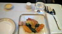 Di kelas bisnis, dihidangkan 3 set menu dinner. Dimulai dengan salad salmon seperti ini. (Wahyu Setyo/detikcom)