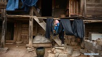 Seorang penduduk desa mengangkut kain linen warna-warni di Desa Banjiang. Foto: Dok. Xinhuanet