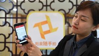 Seorang pekerja staf memperkenalkan mekanisme kerja Sui Shou Pai, sebuah aplikasi yang memungkinkan orang untuk mengungkapkan keluhan mereka dengan mengirimkan gambar. Foto: Dok. Xinhuanet