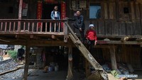 Sebuah pose keluarga untuk sebuah foto di rumah mereka di Desa Banjiang, Kabupaten Guangnan, Provinsi Yunnan di Cina barat daya. Foto: Dok. Xinhuanet