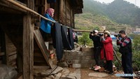 Para fotografer mengambil foto seorang warga desa yang menyiarkan linen yang dicat melalui teknik tradisional. Foto: Dok. Xinhuanet