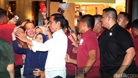 Jokowi melayani warga yang berfoto bersamanya.
