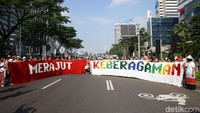 Para ibu-ibu membentangkan kain rajutan di kawasan Sudirman, Jakarta. 