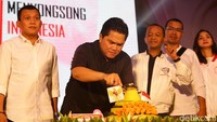 Erick Thohir memotong tumpeng dengan disaksikan relawan milenial Jokowi-Maruf.