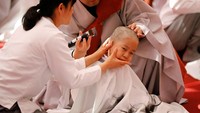 Anak-anak laki-laki tersebut dicukur rambutnya dalam rangka persiapan menjadi Biksu cilik di Kuil Jogye, Seoul, Korea Selatan.