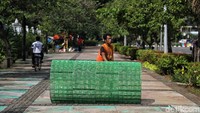 Seorang petugas nampak memasang pelapis resapan air hujan yang termasuk dalam Gerakan Menabung Air Hujan di kawasan depan Balai Kota Jakarta, Senin (22/4/2019).