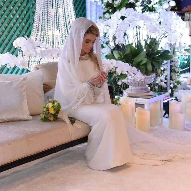 Sebelum memakai gaun pengantin, sebelumnya Sofie tampil dengan gaun panjang putih yang dihiasi renda. Ia juga memakai kerudung dan perhiasan perak sebagai kalung, juga gelangnya. Foto: Dok. Facebook/Kelantan State