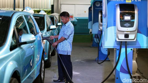 Sopir taksi mengisi baterai mobil listrik BYD 