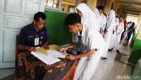 Para siswa antre untuk mengisi absensi sebelum mengikuti UNBK di SMPN 277 Jakarta Utara, Senin (22/4/2019).