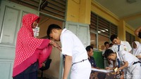 Para siswa juga menyalami guru pengawas sebelum memasuki ruang kelas.