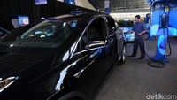 Seorang pengemudi melakukan pengisian mobil listrik di Kantor Pusat Blue Bird, Mampang, Jakarta, Senin (22/4/2019).