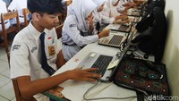 Para siswa tampak serius membaca pertanyaan dan mengisi jawaban lewat layar komputer.