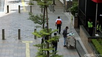 Seorang pedagang berjualan di trotoar Jalan Sudirman, Jakarta.