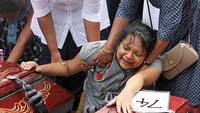 Seorang anak menangis diantara peti jenazah korban teror bom paskah di Sri Lanka, Selasa (23/4/2019). Foto: REUTERS/Athit Perawongmetha