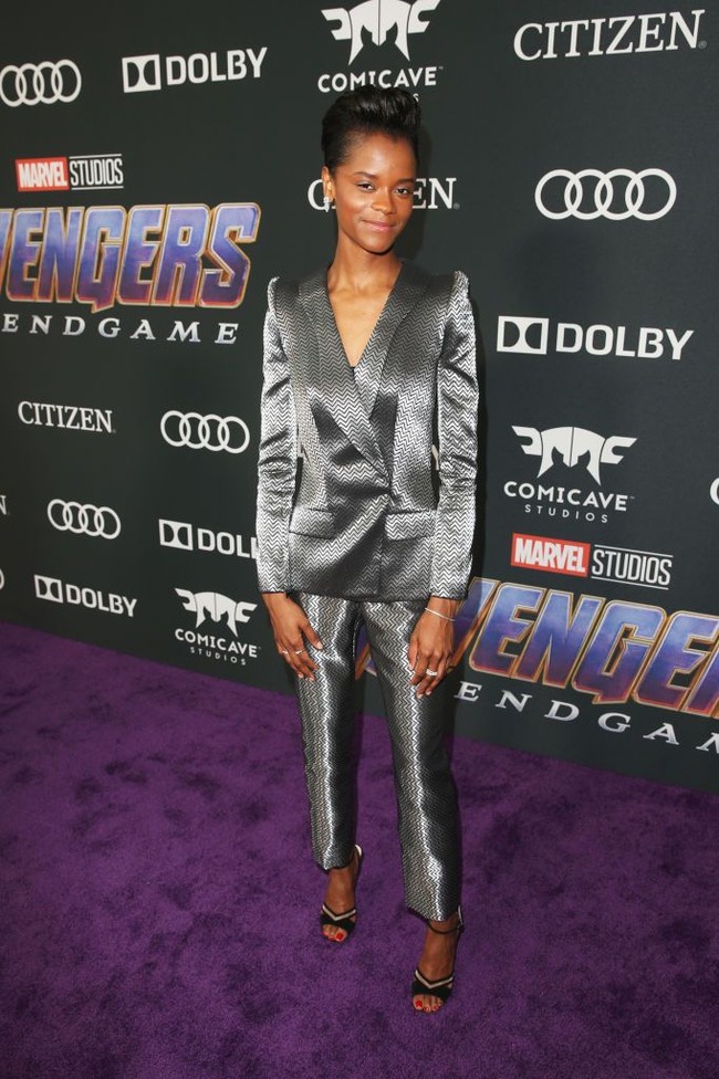 Letitia Wright, pemeran Shuri, tampil edgy dan maskulin dengan setelan jas dan celana panjang warna silver. Rambutnya ditata sleek ke belakangan untuk menonjolkan kesan tomboi namun tetap glamor. Foto: Getty Images