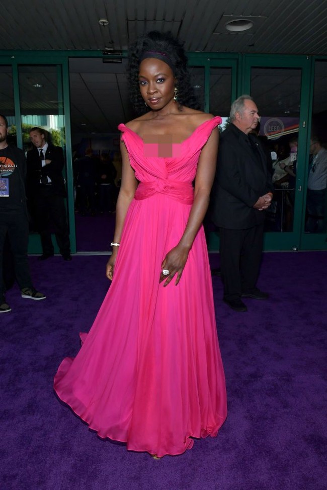 Bintang Black Panther Danai Gurira tampil playful namun seksi dengan gaun pink berpotongan off shoulder. Berbeda dari gayanya di film yang berkepala plontos, kali ini Danai bergaya dengan rambut keriting. Foto: Getty Images
