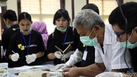 Para peserta mendengarkan penjelasan instruktur tentang cara merawat lukisan.