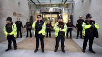 Sejumlah petugas kepolisian bersiaga di sekitar massa demonstran yang melakukan aksi menempelkan diri di kota London, Inggris. Simon Dawson/Reuters.