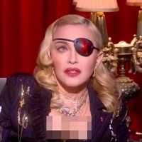 Menjadi bintang tamu acara bincang-bincang di MTV UK baru-baru ini, Madonna pun melengkapi gaya busananya dengan penutup mata itu. Ia tampil seksi dengan blazer berbelahan dada rendah yang dihiasi aksesori bernuansa emas. Foto: YouTube/MTV