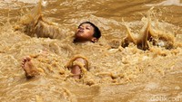 Anak-anak justru memanfaatkan banjir sebagai arena bermain.