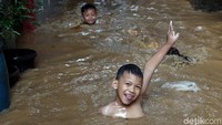 Anak-anak di Bukit Duri, Jakarta, nampak ceria saat bermain air di depan rumah mereka, Jumat (26/4/2019).