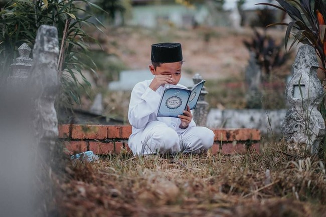 Rupanya foto-foto virl bocah yang ziarah ke makam ibunya ini hanyalah fiktif belaka. Sang fotografer sengaja membuat karya tentang kasih sayang antara  ibu dan anak. Foto: Facebook Atan Mukris