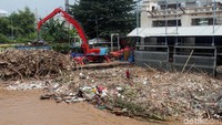 Petugas bahu membahu membersihkan sampah yang menumpuk di kawasan Pintu Air Manggarai, Jakarta, Jumat (26/4/2019).