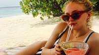 Sedang liburan di Maldives. Shopie Tuner yang berperan sebagai Sansa Stark ternyata juga sangat menikmati minuman jus buah segarnya di pinggir pantai. Foto: Istimewa