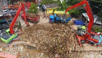 Dua buah alat berat dikerahkan untuk membantu petugas membersihkan sampah yang menumpuk di Pintu Air Manggarai.