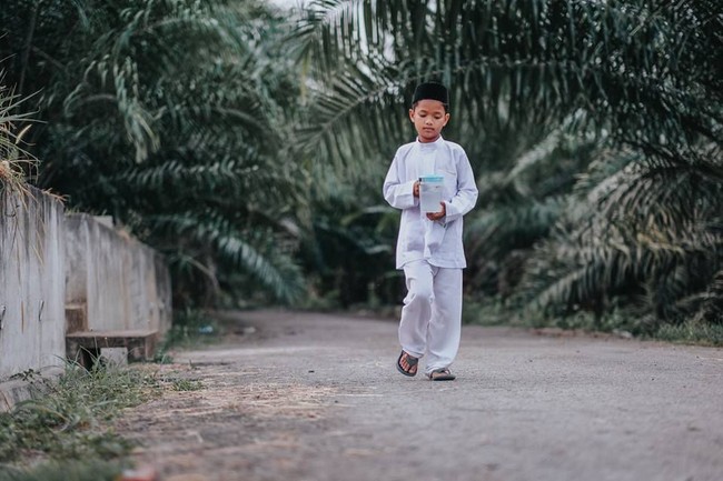 Fotografer asal Malaysia Atan Mukris mencuri atensi setelah mengunggah foto-foto menyayat hati seorang bocah yang pergi mengunjungi ibunya di pemakaman.Foto: Facebook Atan Mukris