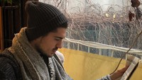 Kali ini gayanya terlihat cukup serius. Ia membaca surat kabar sambil menyesap secangkir kopi hangat. Foto: Instagram tanerurc