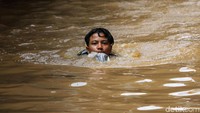 Seorang warga bahkan bisa sambil berenang untuk melintasi jalanan yang terendam banjir disana.