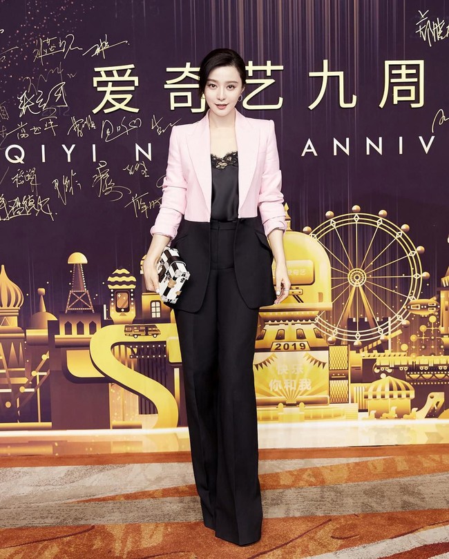 Malam itu, pemain film Lost in Beijing tersebut tampak mengenakan tank top hitam berenda yang dipadukann dengan celana hitam berpotongan longgar. Kemudian ditambahkan blazer yang menarik dengan permainan colorblocking pink-hitam. Adapun clutch yang melengkapi gaya stylish-nya. Foto: Instagram @bingbing_fan