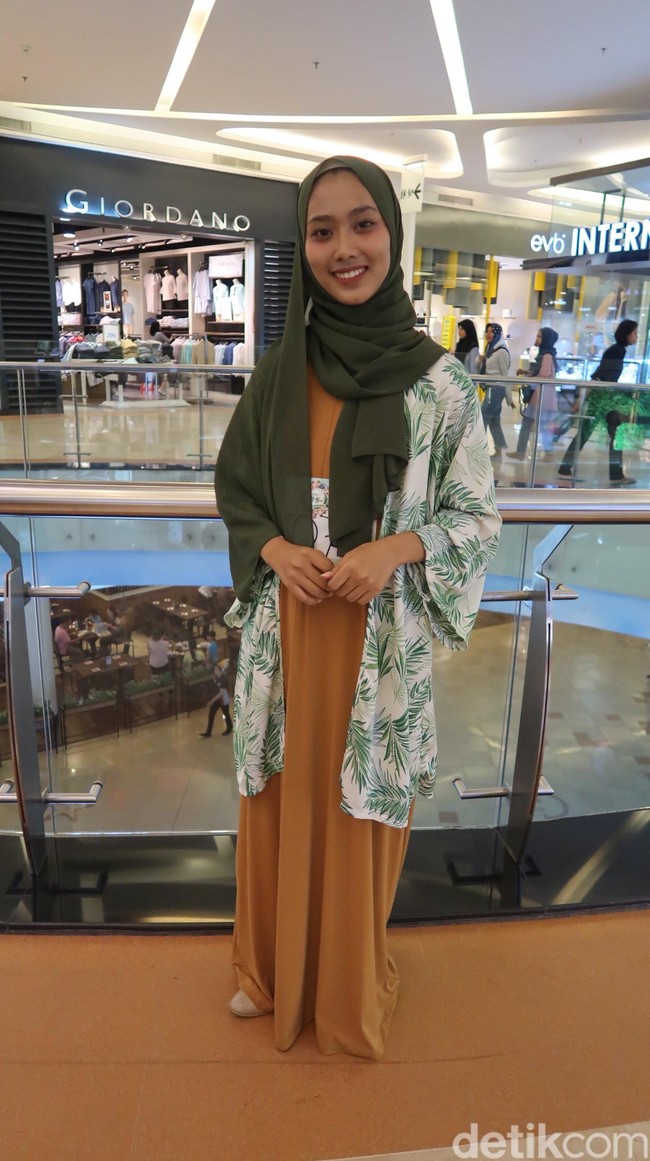 Nur Afifah Masyhurah tampil dengan padanan gaun panjang polos berbahan kaus dan memadukannya bersama outer model kimono dengan print daun hijau yang tampak segar. Model hijab pashmina pun menjadi padanan yang tepat agar keseluruhan tampilan lebih bergaya. Gaya wanita 20 tahun ini bisa jadi inspirasi untuk tampil kasual saat hangout. Foto: Alissa Safiera/Wolipop