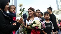 Para relawan juga membagikan bunga kepada warga.