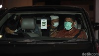 Dengan masker, para penyidik meninggalkan gedung Kemendag dengan mobil terpisah. 