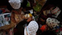Mempelai wanita harus berbaring terlebih dahulu. Kemdian perias akan mulai mengecat wajah calon pengantin dengan warna putih. (REUTERS/Stoyan Nenov)