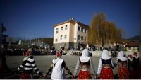 Tradisi selanjutnya adalah menari horo. Ini adalah tarian tradisional yang diadakan di alun-alun kota. Sang mempelai pria tentu saja harus menggandeng erat calon pengantin wanita yang masih menutup mata. (REUTERS/Stoyan Nenov)